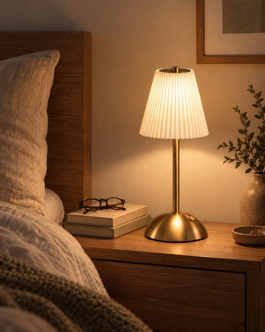 Lampe plissée allumée sur une table de chevet